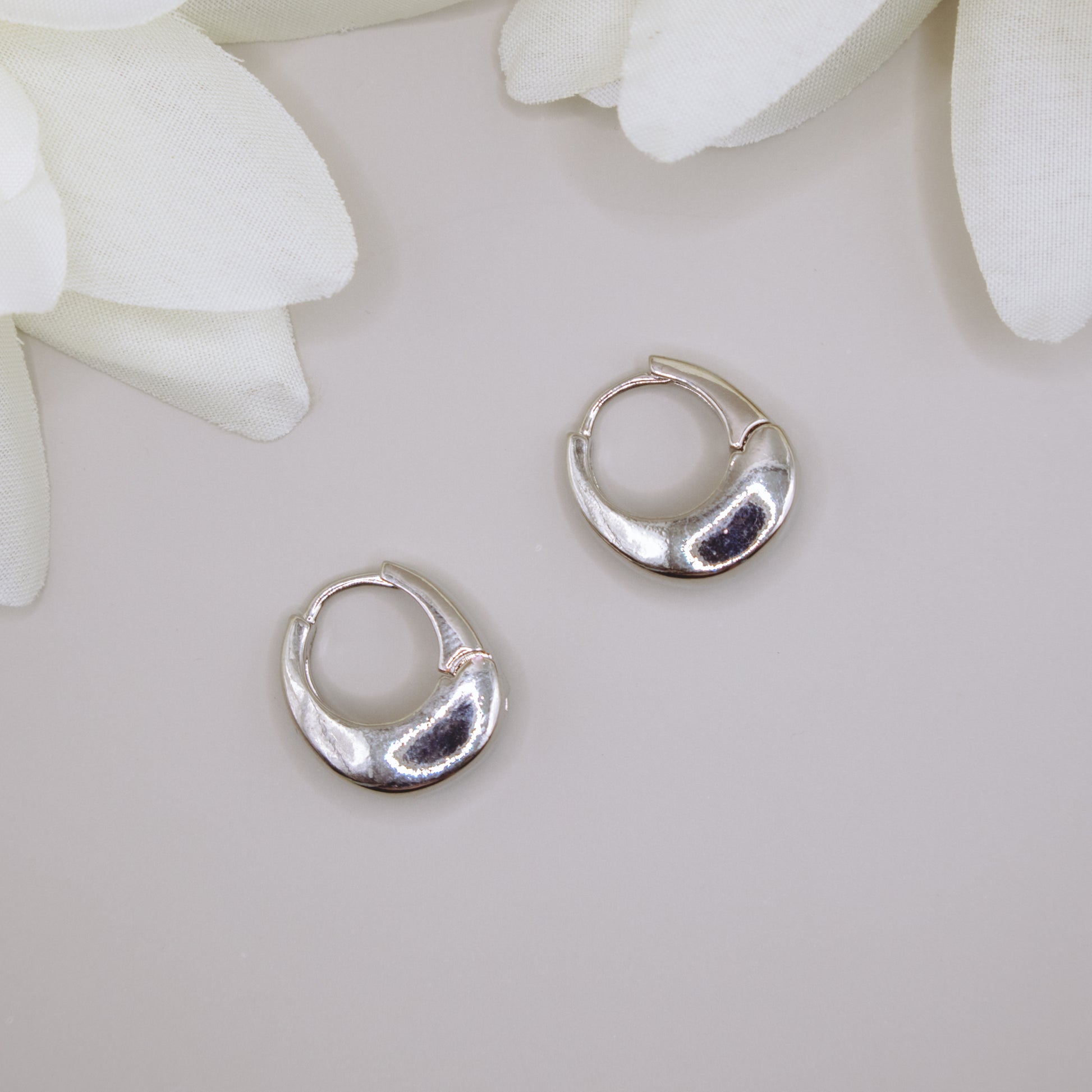 Chunky silver huggies earrings for women, K-pop inspired.