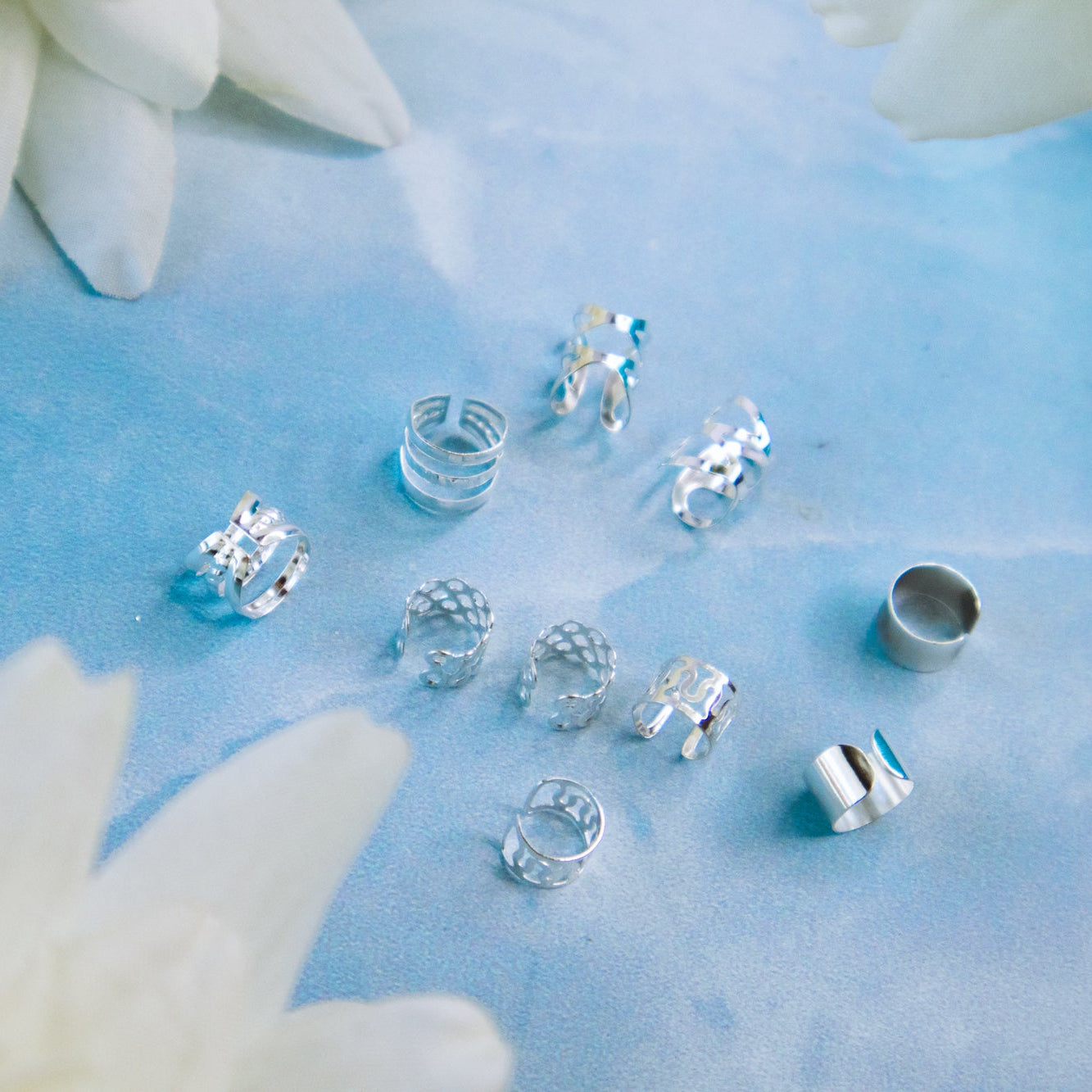 metal braid cuffs, gold and silver, lying on a blue surface