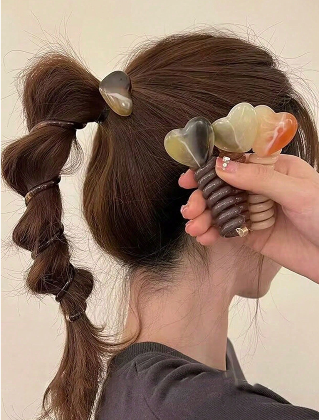 model wearing Korean Ponytail coil, hand holding all colour variants
