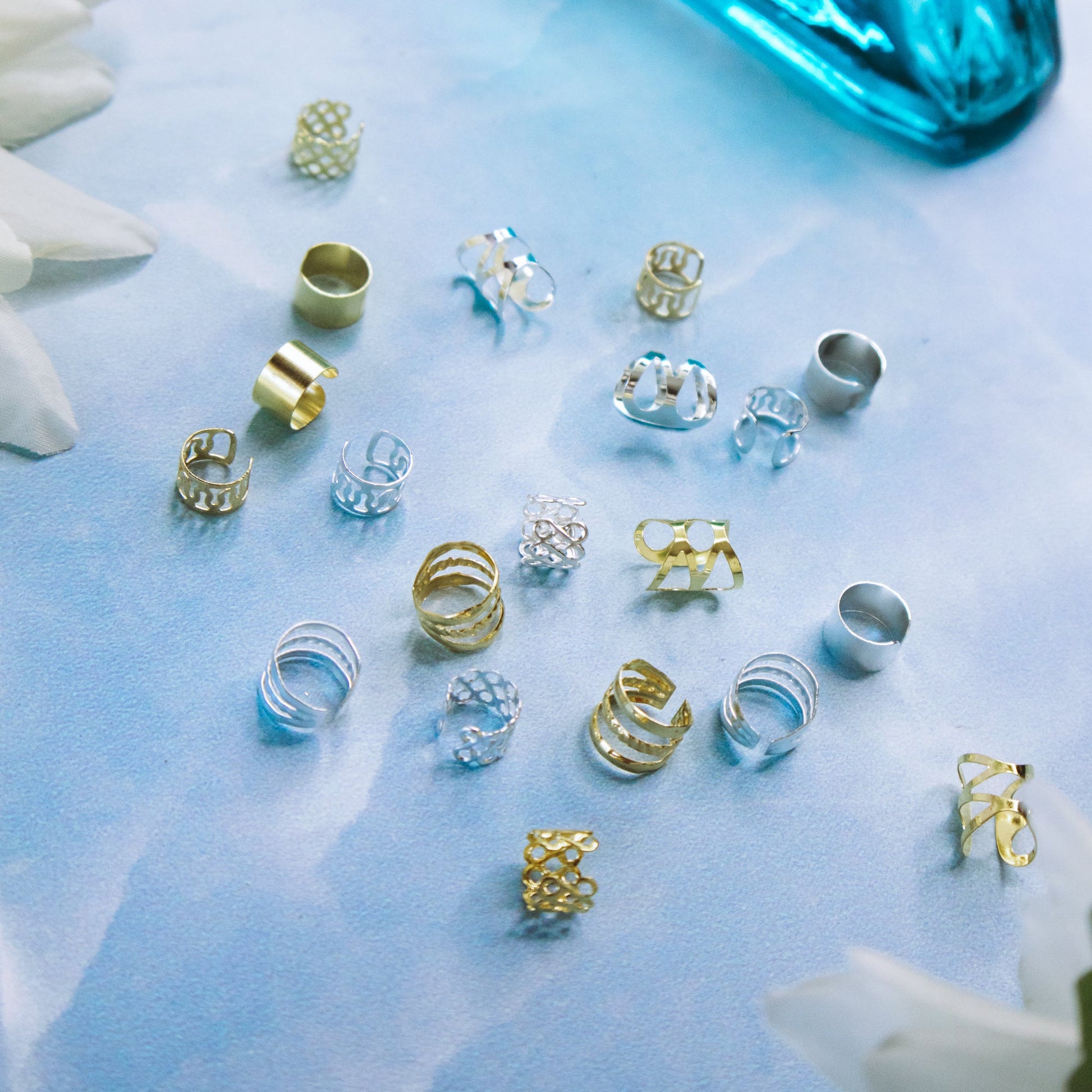 metal braid cuffs, gold and silver, lying on a blue surface