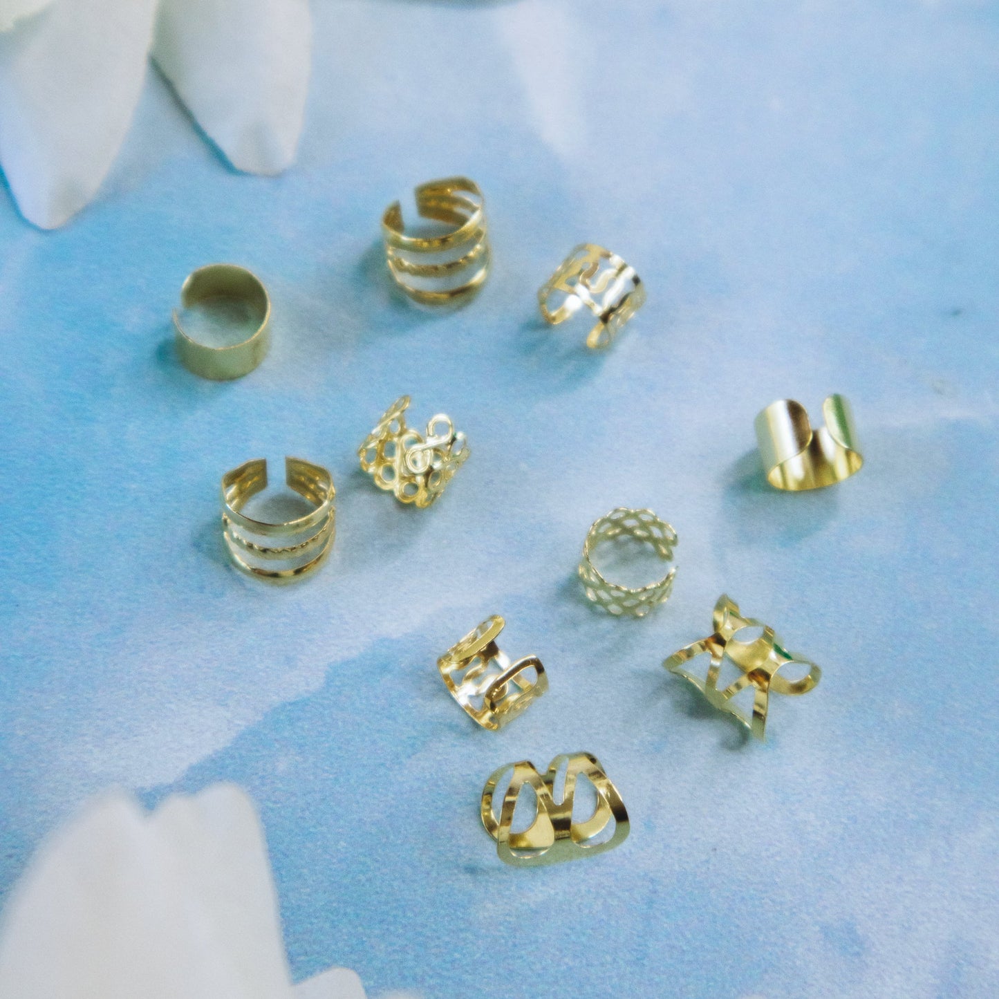 metal braid cuffs, gold and silver, lying on a blue surface